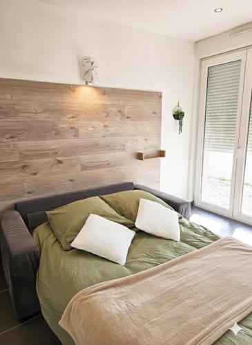 a bedroom with a bed with two pillows on it at studio tout équipé, calme avec terrasse et parking in Audincourt