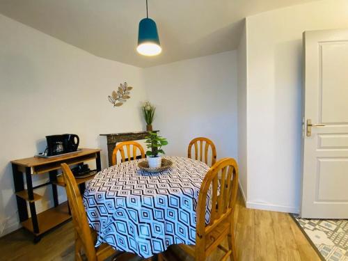 une salle à manger avec une table et des chaises avec une plante dessus dans l'établissement Casa Jacobin, à Angers