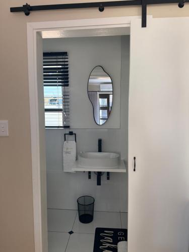 a bathroom with a sink and a mirror at Cathy & P Guesthouse in Hartbeespoort
