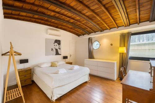 a bedroom with a white bed and a wooden ceiling at Grande Péniche Climatisée avec Terrasse - Proche Paris in Puteaux