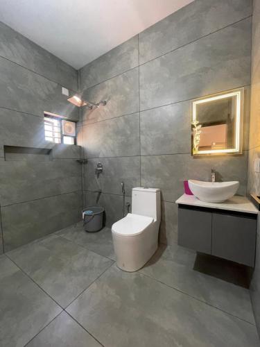 a bathroom with a white toilet and a sink at Vijay Home Stays in Batheri