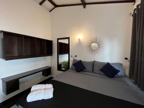 a bedroom with a large bed and a mirror at Hiricurry,Rooms Hostel & Restaurant in Dickwella