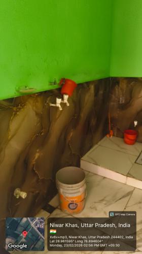 a room with a green wall and a bucket at Sukhram ji ka awas in Morādābād