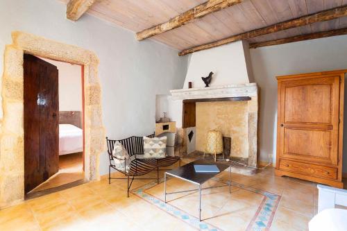a living room with a couch and a fireplace at L'Oustalou in Rosières