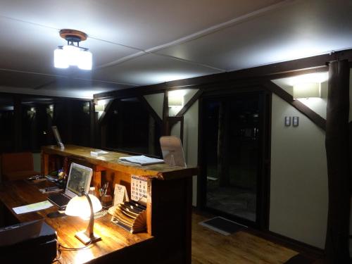 a room with a desk with a laptop and a lamp at Eco Hotel Antuco in Antuco