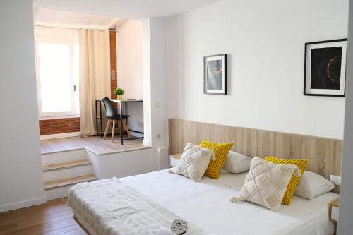 a bedroom with a large white bed with yellow pillows at Hamilton Suites in Barcelona