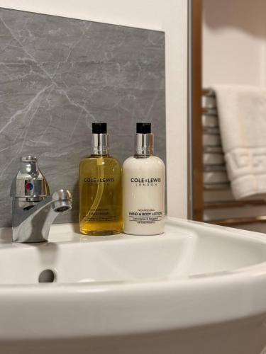 two bottles of soap sitting on a bathroom sink at Contractor Friendly 4 Bed House XBOX Sleeps 6 in Newark-on-Trent
