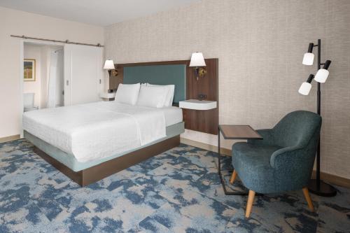 a hotel room with a bed and a chair at Hampton Inn Frostburg in Frostburg