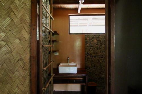 a bathroom with a sink and a window at Palawan Ecolodge in Malabuñgan