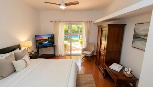 a bedroom with a large white bed and a television at Abraham's 4 BHK villa, By Gonserv in Jāmb