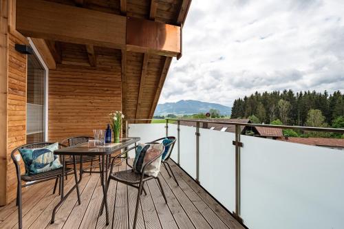 a patio with a table and chairs on a deck at Grünten-Chalet in Oy-Mittelberg