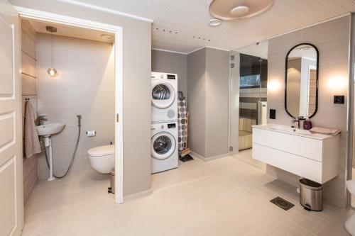 a bathroom with a washing machine and a washer and dryer at Villa Kannas 1 in Juuka
