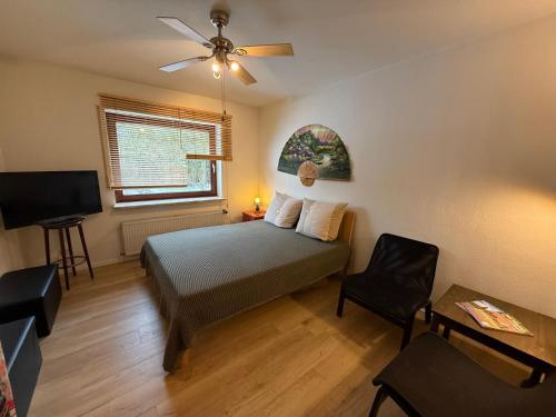 a bedroom with a bed and a ceiling fan at Schicke kleine Bude (Pretty tiny Flat) in Neuenkirchen