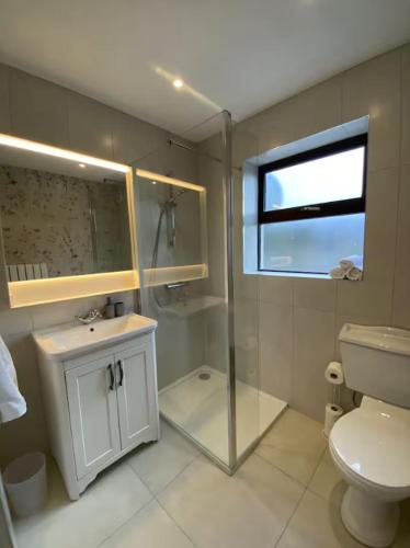 a bathroom with a toilet and a sink and a window at Lakeview in Keel