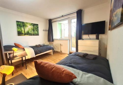 a bedroom with two beds and a flat screen tv at Moderne Wohnung mit Balkon und top Anbindung in Unna