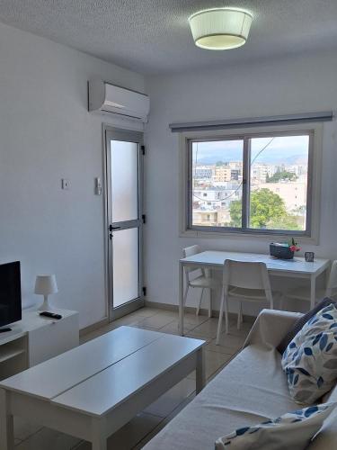 a living room with a couch and a table and a window at Delphi Court - large 1 bed -sleeps 4, Near sea/beach - free wifi in Limassol