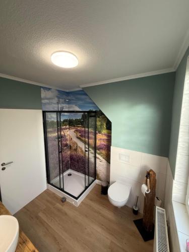 a bathroom with a toilet and a glass shower at Ferienwohnung Meyer in Neuenkirchen