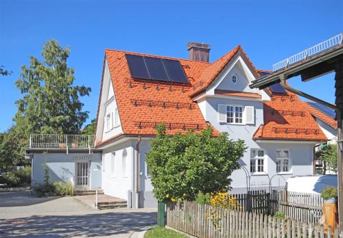 a white house with solar panels on its roof at Villa Primavera in Nesselwang