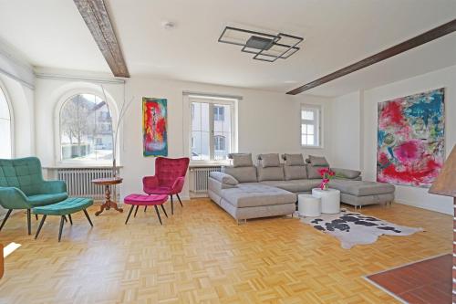 a living room with a couch and colorful chairs at Villa Primavera in Nesselwang