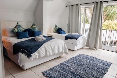 a bedroom with two beds with blue pillows at St Andrews exclusive guesthouse in Klerksdorp