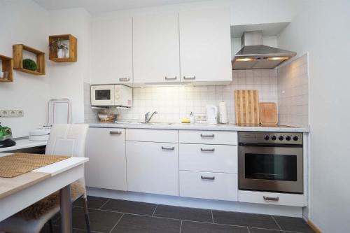 a kitchen with white cabinets and a stove at Bergliebe in Nesselwang