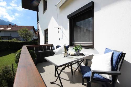 a patio with a table and chairs and a window at Bergliebe in Nesselwang