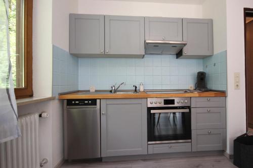 a kitchen with white cabinets and a sink at Am Mühlbach in Nesselwang
