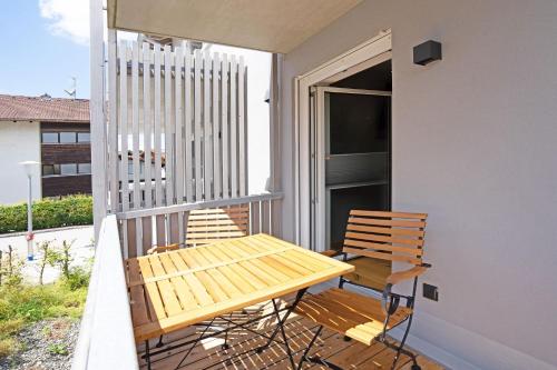 a wooden table and chairs on a balcony at Exclusive Maisonettewohnung! in Nesselwang