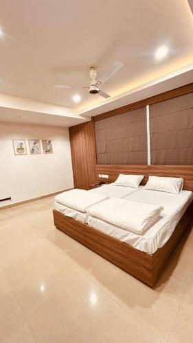 a bedroom with a large bed with a wooden headboard at MALAPPURAM RESIDENCY in Malappuram