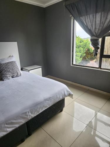 a bedroom with a bed and a large window at Fumas guesthouse in Duvhapark