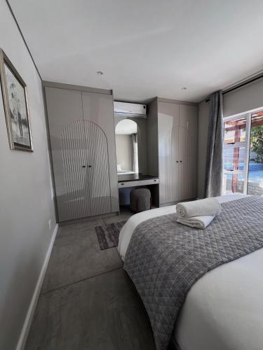 a bedroom with a large bed and a bathroom at Villa Bella in George