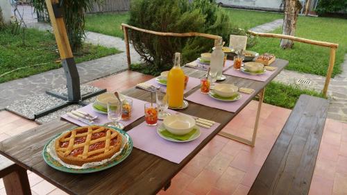 einen Tisch mit einer Waffel, einem Teller Waffeln und Orangensaft in der Unterkunft Dragonfly B&B in Certosa di Pavia