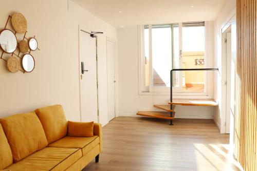 a living room with a couch and a window at Hamilton Suites in Barcelona