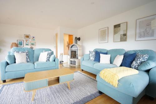 a living room with blue couches and a coffee table at Panoramaweg in Wertach