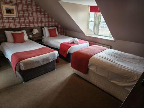 a hotel room with two beds and a window at Chieftain Hotel in Inverness