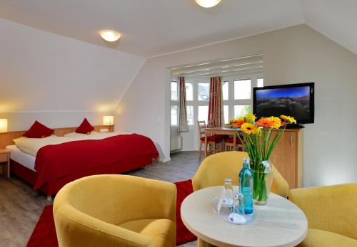 a hotel room with a bed and a table and chairs at Landhotel Albers in Schmallenberg