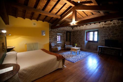 a bedroom with a bed and a living room at Rectoral de Castillon in Pantón