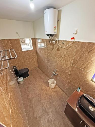 a bathroom with a shower with a toilet and a sink at Hotel Fortune 36 in Bangalore
