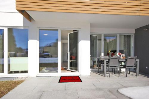 a patio with a table and chairs and sliding glass doors at N-Appartement Falkenstein in Nesselwang