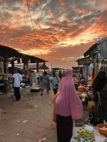 a group of people walking through a market at sunset at Tida-Ecolodge in Kartung