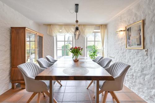 a dining room with a wooden table and white chairs at Haus Bella in Schwangau