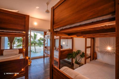 a room with two bunk beds and a balcony at Monkey Tribe Alleppey in Alleppey