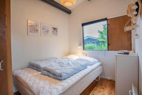 a bed in a room with a window at M252-Vaeggerlose-Bjergfruevej-6 in Bøtø By