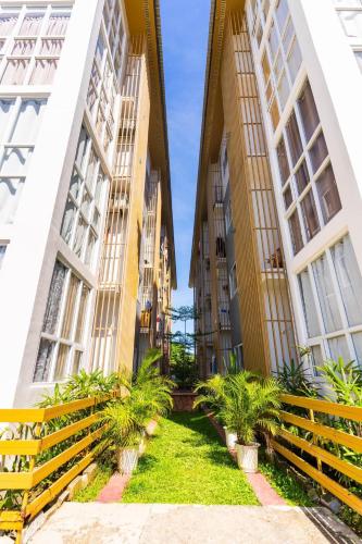 a courtyard between two tall buildings with plants at Bayanihan Flats 2 in Mactan