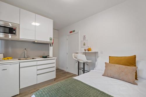 a small white kitchen with a bed and a sink at Brito's Guest House - Monthly Rentals & Digital Nomads in Funchal
