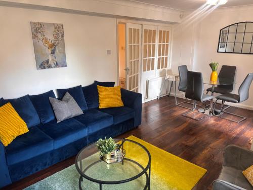 a living room with a blue couch and a table at Spacious 3-bed apartment close to Birmingham City with free parking with Netflix contractor stays welcome in Birmingham