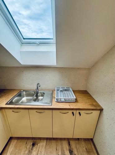 a kitchen with a sink and a window at Willa u Marioli in Ściegny