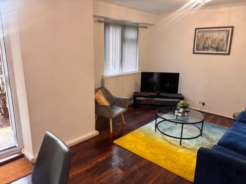 a living room with a couch and a table at Spacious 3-bed apartment close to Birmingham City with free parking with Netflix contractor stays welcome in Birmingham