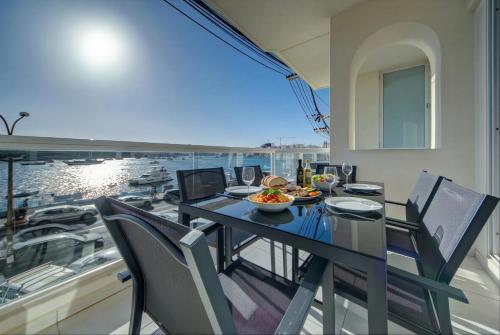 a dining room with a table and chairs on a balcony at Tigné Seafront Apartments & Penthouse with Heated Jacuzzi in Sliema