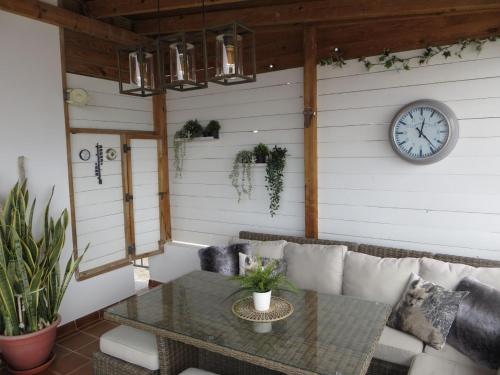 a room with a table and a clock on a wall at Stunning Ocean Views in Puerto de Mogan in Puerto de Mogán